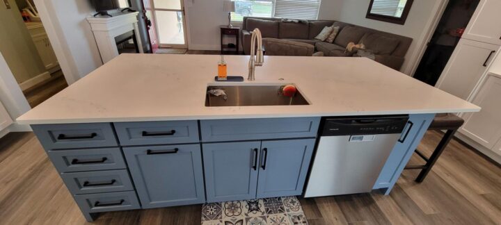 Modern kitchen cabinet remodel with white cabinetry, large island, quartz countertops, and custom kitchen storage